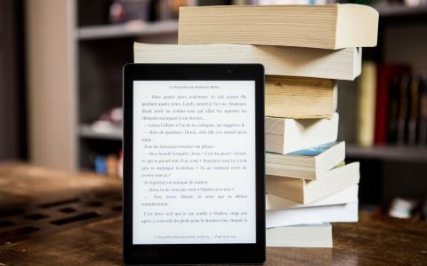 E-Reader vor Bücherstapel